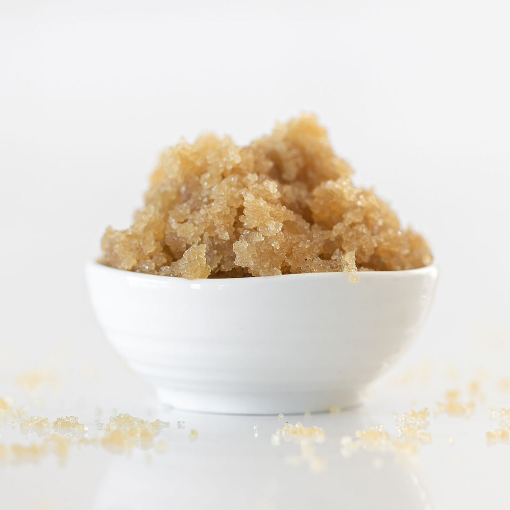 Brown sugar in a white bowl on a light background