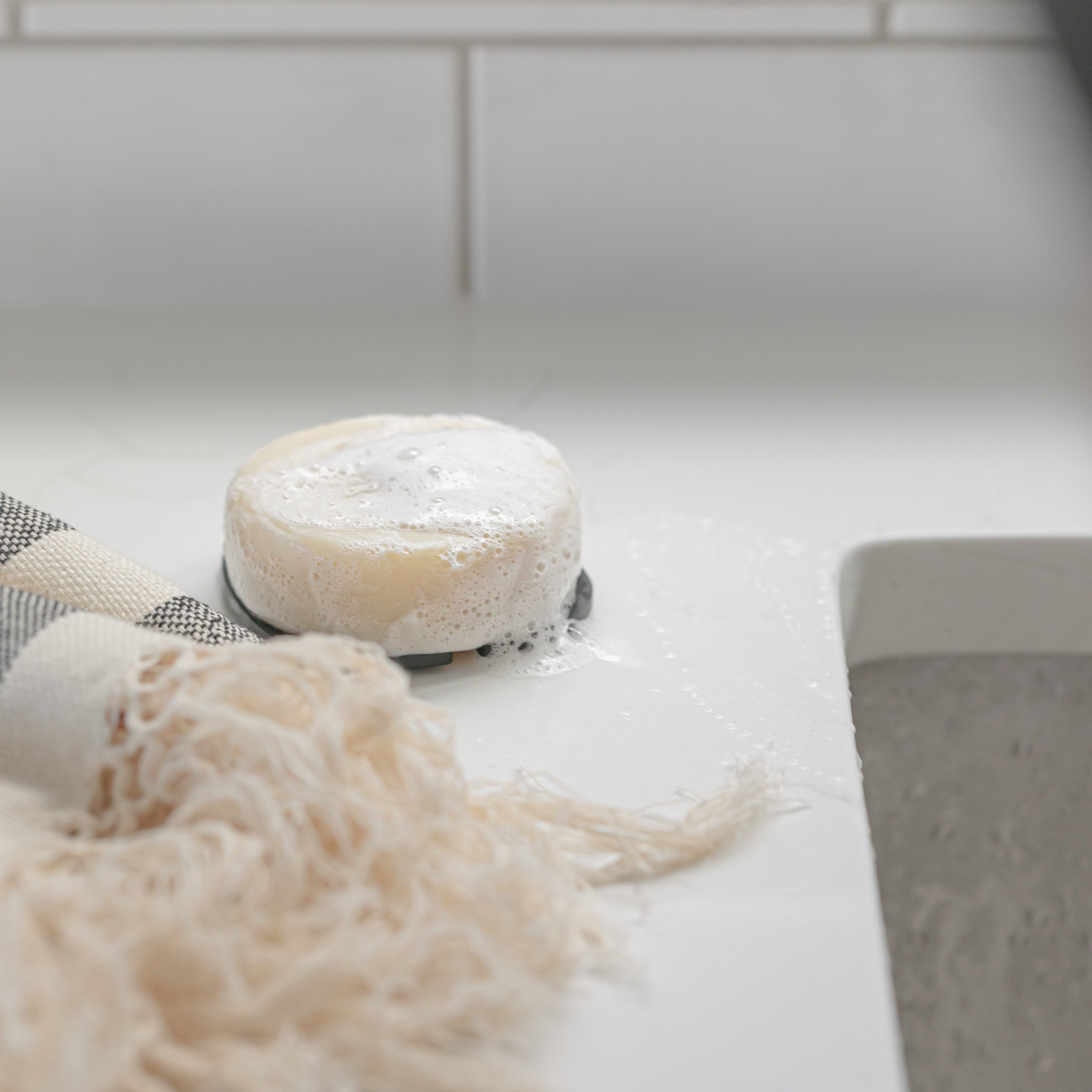 lathered soap bar on counter surface with a blurred background
