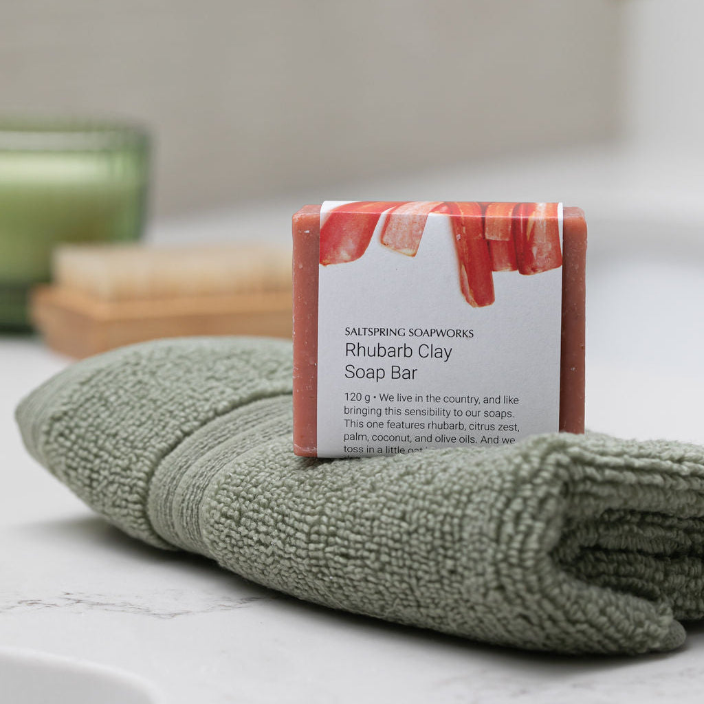 Saltspring Soap Rhubarb Clay Bar on a green towel in a bathroom setting