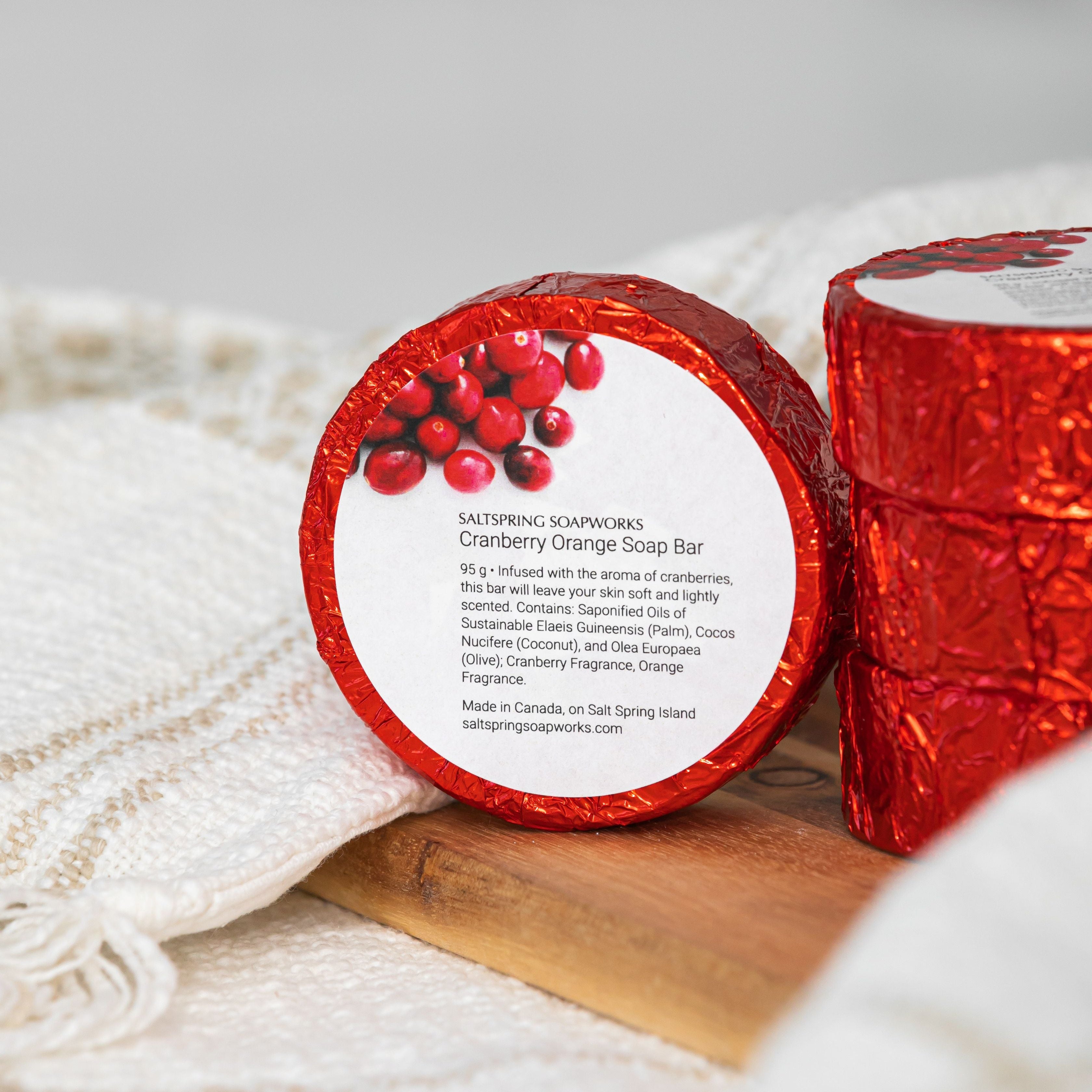 wrapped in red foil soap bar with a white label on a wooden surface