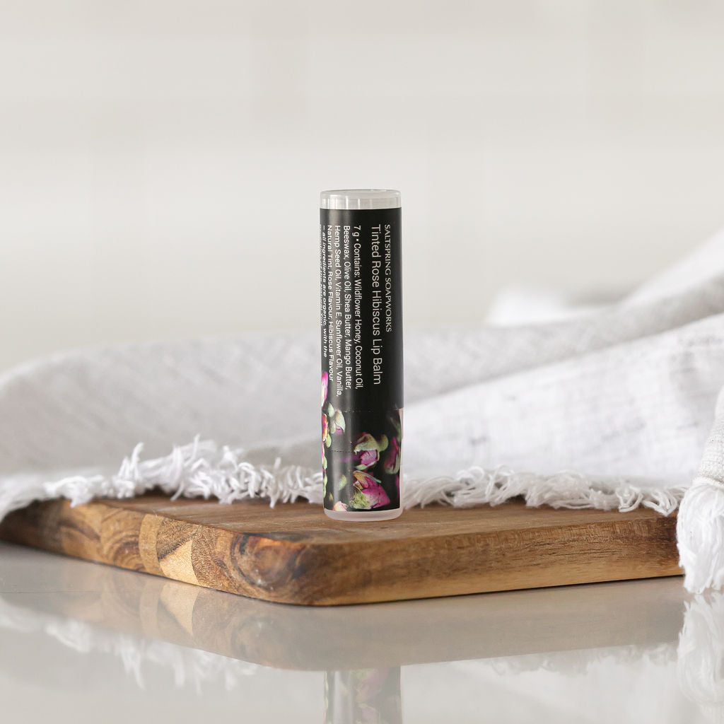 Saltspring Soapworks Tinted Rose Hibiscus Lip Balm on wooden tray
