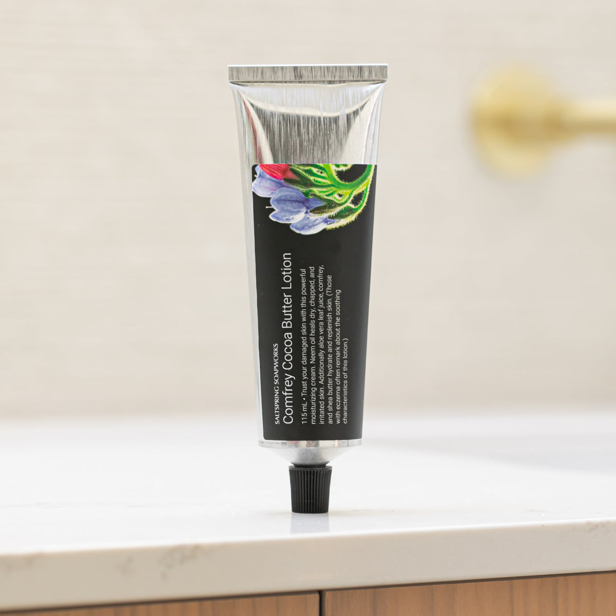 Saltspring Soapworks Comfrey Lotion tube standing on it's lid on counter